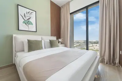 a white bed in a room with a large window at Chic Liva 1br Family-friendly Great Amenities in Nadd Shubayḩ