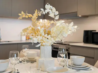 a table with a vase with white flowers on it at SmartStay at Grande Signature - Burj Khalifa View - 5 min Dubai Mall - Downtown Dubai - Brand New Luxury Apartments in Dubai