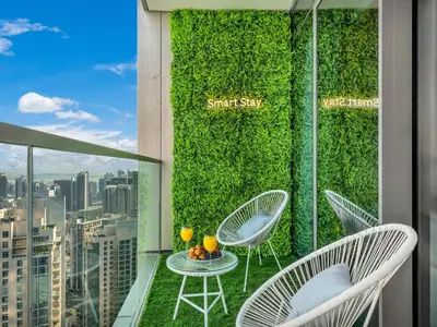 a balcony with chairs and a green wall at SmartStay at Grande Signature - Burj Khalifa View - 5 min Dubai Mall - Downtown Dubai - Brand New Luxury Apartments in Dubai