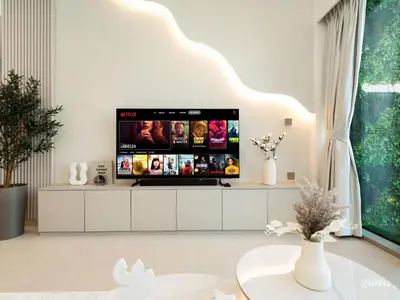 a living room with a flat screen tv on a white cabinet at SmartStay at Grande Signature - Burj Khalifa View - 5 min Dubai Mall - Downtown Dubai - Brand New Luxury Apartments in Dubai