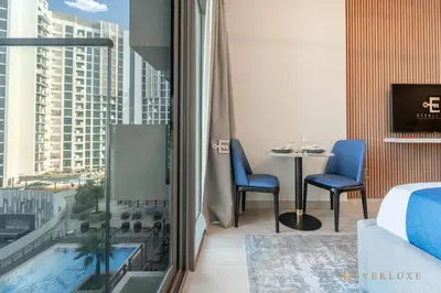 a hotel room with a balcony with a table and chairs at Everluxe Modern Pool View Studio In Al Jaddaf in Dubai