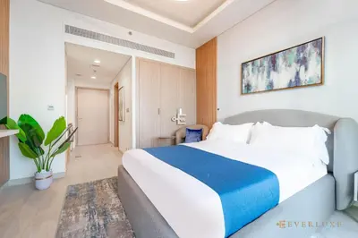 a bedroom with a large bed in a room at Everluxe Modern Pool View Studio In Al Jaddaf in Dubai