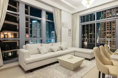 a living room with a white couch and large windows at Lux Unit with Burj & Fountain View I Walk Dubai Mall in Dubai