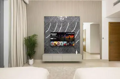 a living room with a tv on a wall at Lux Unit with Burj & Fountain View I Walk Dubai Mall in Dubai