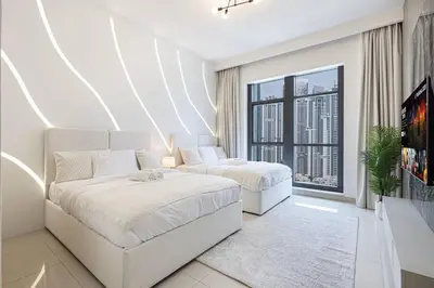 a white bedroom with two beds and a large window at Lux Unit with Burj & Fountain View I Walk Dubai Mall in Dubai