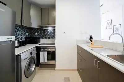 a kitchen with a sink and a washing machine at Stunning 1BR with Palm Jumeriah View in Marina in Dubai