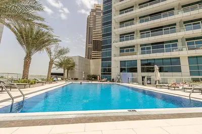 a large swimming pool in front of a building at Stunning 1BR with Palm Jumeriah View in Marina in Dubai