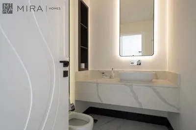 a white bathroom with a sink and a mirror at Mira Holiday Homes - Lovely new 1 bedroom in Downtown in Dubai