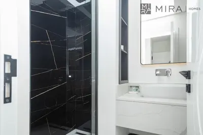 a bathroom with a shower with a sink and a mirror at Mira Holiday Homes - Lovely new 1 bedroom in Downtown in Dubai