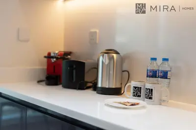 a counter with a coffee maker and a plate of food at Mira Holiday Homes - Lovely new 1 bedroom in Downtown in Dubai