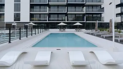 a swimming pool in front of a building at Furnished 1br In Jvc Pool Access Free Parking in Dubai
