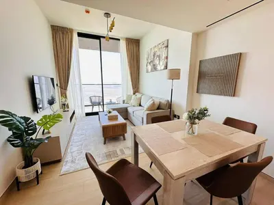 a living room with a wooden table and chairs at Furnished 1br In Jvc Pool Access Free Parking in Dubai