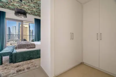 a bedroom with white cabinets and a bed with a window at Prime Location Full Burj View in Downtown Dubai in Dubai