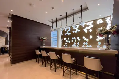 a bar with white chairs and a brown wall at GuestReady - Charm stay in Dubai Marina in Dubai