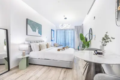 a white bedroom with a bed and a table at Exquisite Modern Home Minutes from Downtown Dubai in Dubai