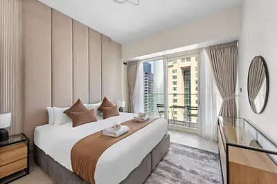 a bedroom with a large bed with a large window at 2-Bedroom Apartment in ME DO RE in Dubai