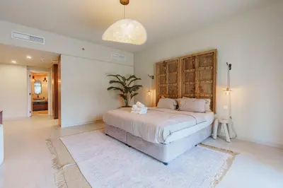 a bedroom with a large bed with a wooden headboard at Spacious 4BR in Madinat Jumeirah Living in Dubai