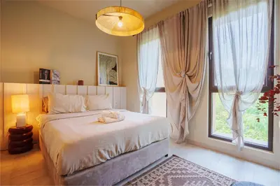 a bedroom with a large bed and a large window at Spacious 4BR in Madinat Jumeirah Living in Dubai