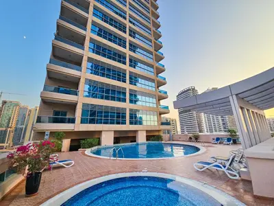 a building with a swimming pool in front of a building at EasyGo- Comfy STU in Dubai Marina -Zum04 in Dubai