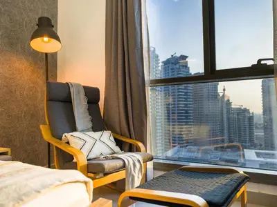 a hotel room with a chair and a window at EasyGo- Comfy STU in Dubai Marina -Zum04 in Dubai