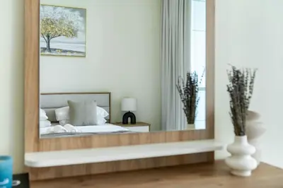 a mirror in a bedroom with a bed and a window at Classic Retreat in JBR with Private Beach Access in Dubai