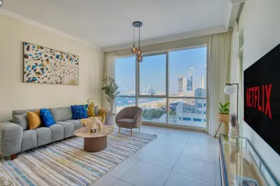 a living room with a couch and a large window at Classic Retreat in JBR with Private Beach Access in Dubai