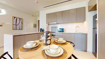 a kitchen with a wooden table with plates and cups on it at Grande Residence - Contemporary One Bedroom in Dubai