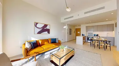 a living room with a yellow couch and a table at Grande Residence - Contemporary One Bedroom in Dubai