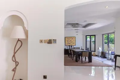 a living room with a floor lamp and a dining room at Private Pool & Direct Beach Access-4BDR Villa in Dubai