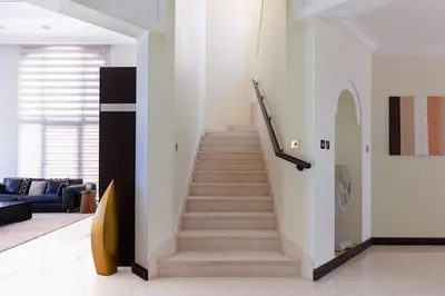a staircase in a living room with a stair case at Private Pool & Direct Beach Access-4BDR Villa in Dubai