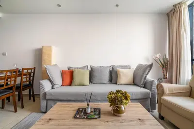 a living room with a gray couch with colorful pillows at GuestReady - Modern retreat in JLT in Dubai