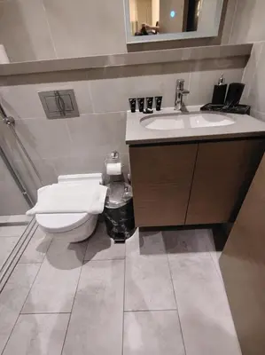 a bathroom with a white toilet and a sink at Luxury apartment in Sobha Hartland Waves near Dubai mall and Burj Khalifa in Dubai