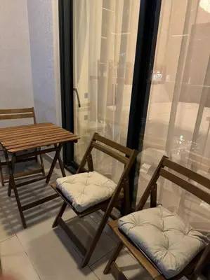 two chairs and a table in a room with a window at Luxury apartment in Sobha Hartland Waves near Dubai mall and Burj Khalifa in Dubai