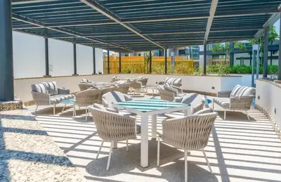 a patio with chairs and a table and a table and chairs at Luxury apartment in Sobha Hartland Waves near Dubai mall and Burj Khalifa in Dubai