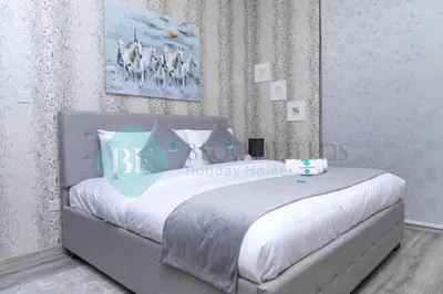 a bedroom with a bed with blue and white pillows at Bloomfields Cozy 1br In Silicon Oasis in Dubai