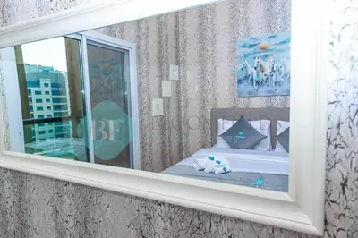a mirror in a room with a bed with a stuffed animal at Bloomfields Cozy 1br In Silicon Oasis in Dubai