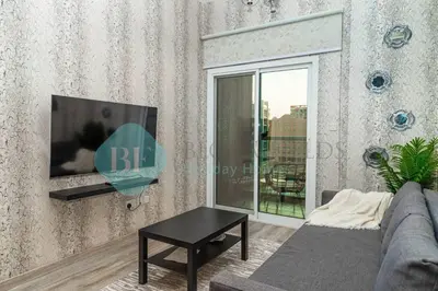 a living room with a couch and a tv on a wall at Bloomfields Cozy 1br In Silicon Oasis in Dubai