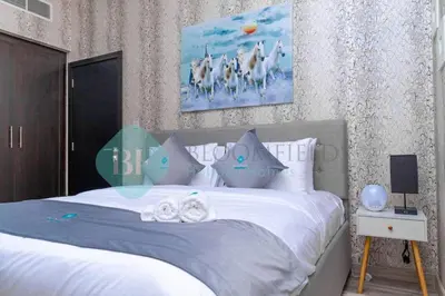 a bedroom with a large bed with white sheets at Bloomfields Cozy 1br In Silicon Oasis in Dubai