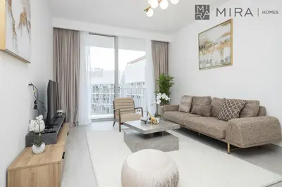 a living room with a couch and a tv at Mira Holiday Homes - Luxury and cosy 1 bedroom in JVC in Dubai