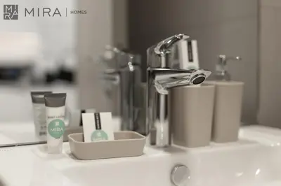 a bathroom counter with a sink with products on it at Mira Holiday Homes - Luxury and cosy 1 bedroom in JVC in Dubai