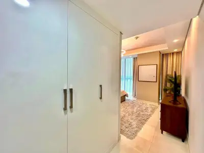 a large white cabinet in a room with a bedroom at Prime Location , Bright Studio , High Floor in Dubai
