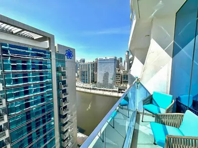a balcony with chairs and a view of a city at Prime Location , Bright Studio , High Floor in Dubai