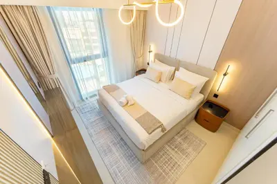 a bedroom with a bed with white sheets and a window at 2 Br in in Burj Crown by Pk Holidays in Dubai