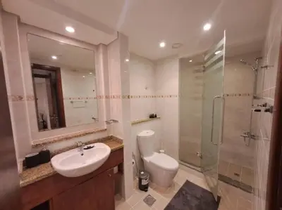 a bathroom with a toilet and a sink and a shower at Spacious 1BR unit with Lake View in Dubai