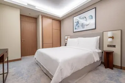 a bedroom with a large white bed and a desk at Luxury 2BR at Address Opera Downtown City View in Dubai