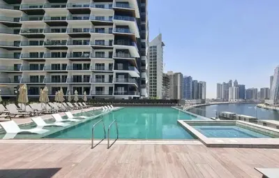 a swimming pool with chairs and a building at Burj Khalifa & Lagoon View , Private 1 Bedroom in Dubai