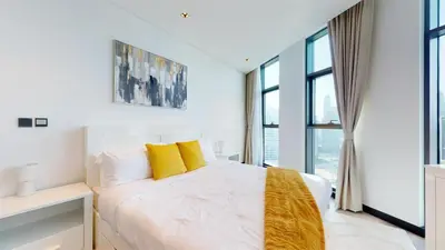 a bedroom with a white bed with yellow pillows at Burj Khalifa & Lagoon View , Private 1 Bedroom in Dubai