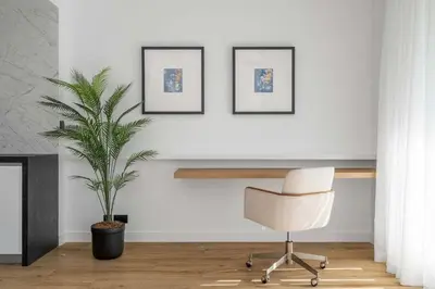 a white room with a chair and a plant at Silkhaus Chic 3BDR & maid room in Dubai Marina in Dubai