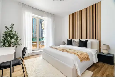 a white bedroom with a large bed and a window at Silkhaus Chic 3BDR & maid room in Dubai Marina in Dubai