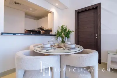 a dining room with a table and chairs in a room at LUX The Silverene Marina View Suite 4 in Dubai